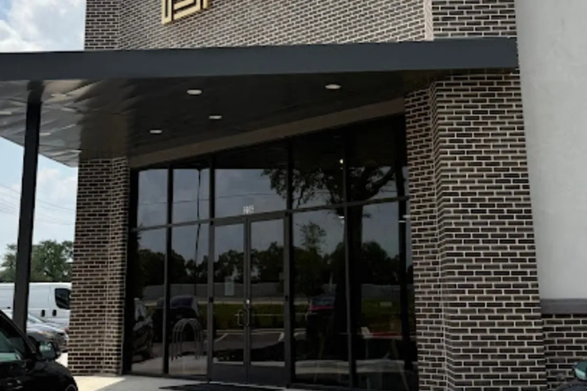 Brick storefront entrance with glass doors and Arwa Yemeni Coffee signage at the Cedar Park location