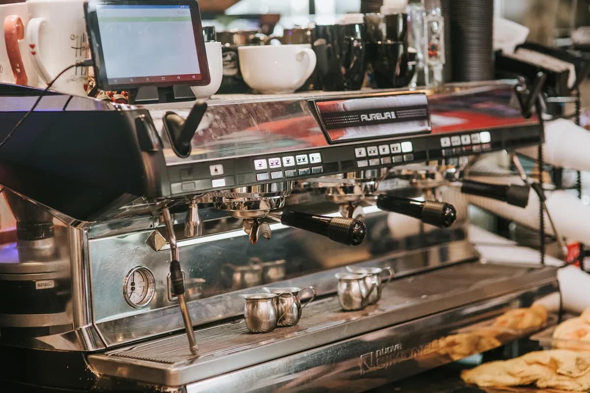 Chrome espresso machine and register on the Cuppa Austin counter beside pastries