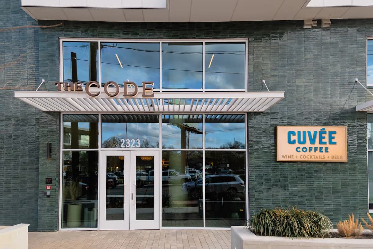 Cuvee Coffee storefront at The Code building with orange sign and glass entry doors