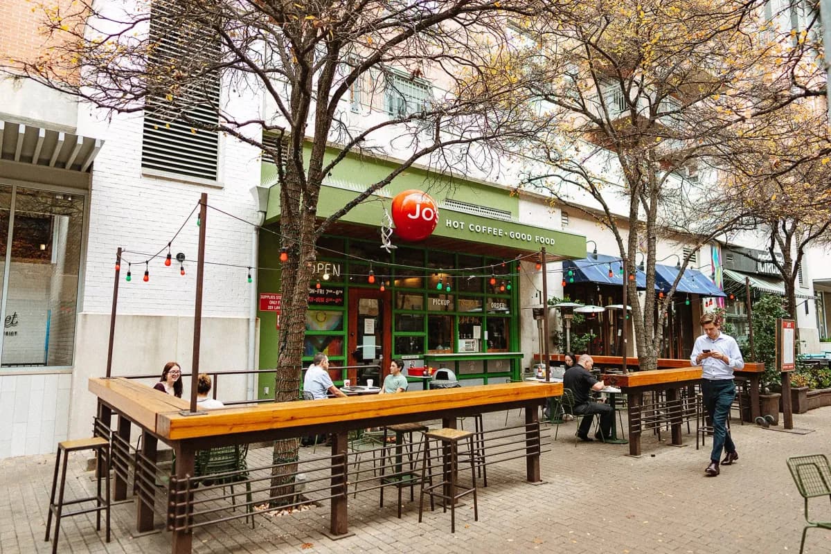 Jo's Coffee downtown storefront with tree-shaded outdoor bar seating on the 2nd Street plaza