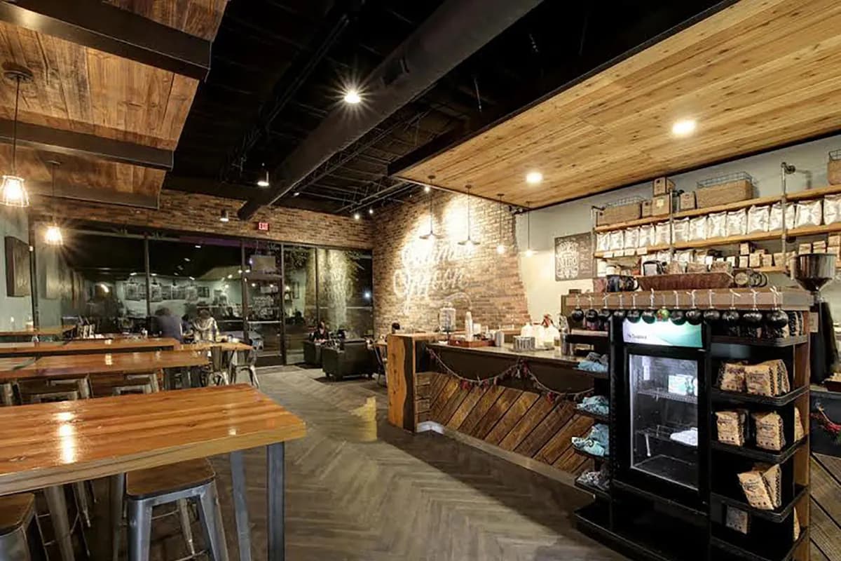 Wide interior with wood-clad ceiling, long counter, retail coffee shelves and communal tables